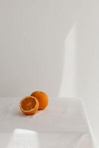 Kaboompics - Two Oranges at the Bottom of a White Background, Vertical Citrus Still Life with Copy Space