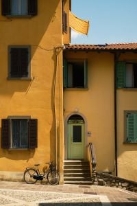 Kaboompics - Yellow Italian House With Green Door and Parked Bicycle