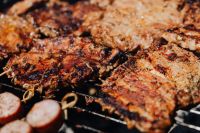 Kaboompics - Close-Up of Juicy Pork Neck Steaks and Sliced Sausages on a Hot Grill