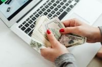 Kaboompics - Hands Counting US Dollar Bills by Laptop