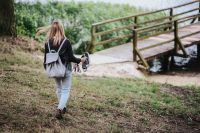 Kaboompics - Woman with a backpack walking towards a wooden pier