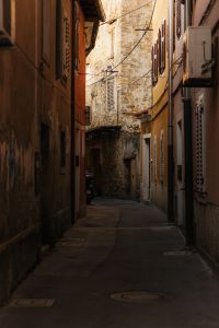 Kaboompics - Narrow Trieste Alley Framed by Stone Arch and Shuttered Windows