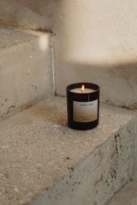 Kaboompics - Candle Burning in a Sunlit Concrete Corner