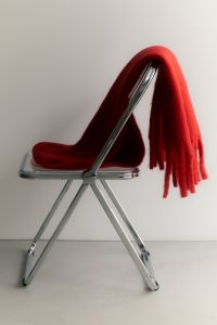 Kaboompics - Red Fringed Scarf on an Acrylic Chair for Winter Interior Aesthetic