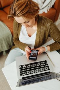 Kaboompics - Overhead Home Office: Hands Using a Phone Above a Laptop with Glasses