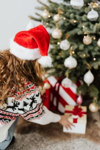 Kaboompics - Woman in Santa Hat Placing Christmas Gift Under Tree