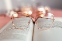 Kaboompics - Wide Open Book and Eyeglasses Still Life with Warm Light