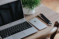 Kaboompics - Silver Acer laptop on a wooden desk with a green plant, pencils and an Apple iPhone