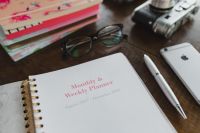 Kaboompics - Close-Up Eyeglasses, Vintage Camera and Smartphone Beside Pink Planner
