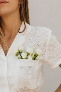 Kaboompics - White Flowers in Pocket of Eyelet Blouse Close-Up
