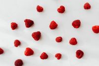 Kaboompics - Scattered Fresh Raspberries On White Marble