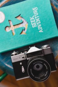 Blue notebooks and a camera on a blue wooden stool