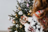 Kaboompics - Woman Holding Christmas Baubles by Tree