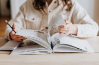 Kaboompics - Woman Reading Open Book with Pencil in Hand