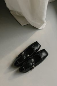 Kaboompics - Black Buckled Leather Shoes on Neutral Floor