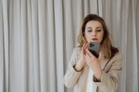 Kaboompics - Woman Checking Her Smartphone against a Neutral Curtain Background