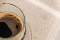 Kaboompics - Single Espresso Glass on a Taupe Coaster, Neutral Coffee Still Life