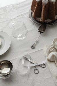 Kaboompics - Close Up White Ribbon and Scissors on Linen Christmas Table