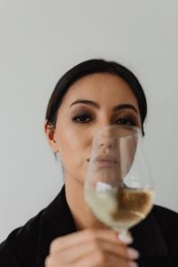 Asian Woman Wine Tasting in a Black Outfit with White Wine