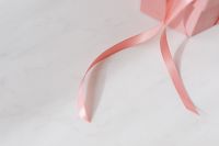 Kaboompics - Light pink velvety box with satin ribbon on white marble