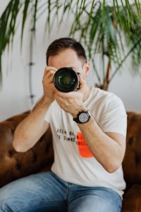 Photographer at Work Editing Photos on Laptop with DSLR Camera, Telephoto Lens and Home Studio Gear