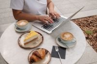 Kaboompics - Woman Working on a Laptop with Coffee and Pastries