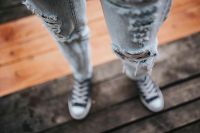 Kaboompics - Woman in black Converse sneakers and ripped jeans