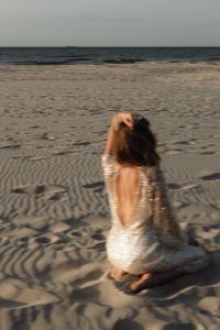 Kaboompics - Solitary Woman Sitting on Beach in Backless Sequin Dress