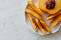 Kaboompics - Peach Slices on White Plate with Bright Copy Space