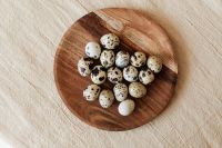 Kaboompics - Loose Speckled Eggs on a Round Wooden Board, Rustic Easter Still Life for Recipe Content