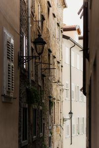 Kaboompics - Narrow Historic Alley with Iron Wall Lamps and Stone Facades