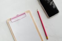 Kaboompics - Clipboard on a marble table, a mobile phone and a pencil, copy space