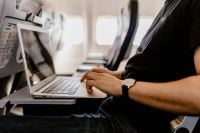 Kaboompics - Unrecognizable man with notebook sitting inside an airplane