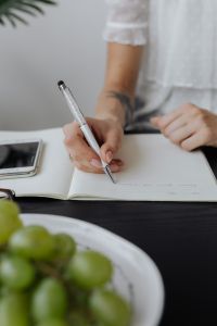 Kaboompics - Writing Work Notes in a Notebook at the Office