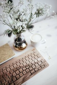 Kaboompics - White Flower Vase and Coffee above a Wooden Keyboard