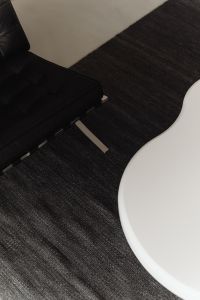 Kaboompics - Black Leather Chair and White Sculptural Coffee Table