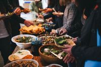 Kaboompics - People by a banquet table full with food
