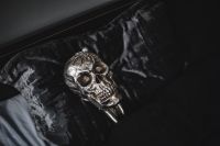 Kaboompics - Silver Skull Lying on Black Velvet, Wide Dark Halloween Background