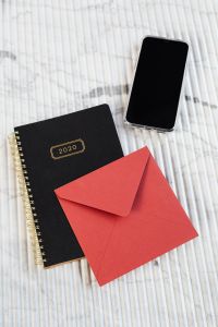 Kaboompics - Red Envelope, 2020 Planner and Smartphone on Marble, Stationery Flat Lay
