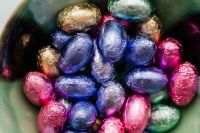 Kaboompics - Close-Up of Colorful Foil Eggs Packed in a Green Bowl