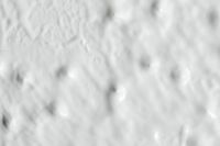 Kaboompics - White Painted Wall Macro with Uneven Bumpy Texture and Scattered Gray Pores