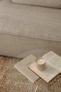 Kaboompics - Lit Candle on Open Book and Glass Coffee Table beside Sofa