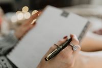 Kaboompics - Writing in a notebook lying in bed, with coffee, candles, and gingerbreads