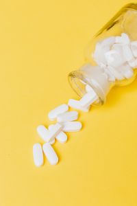 Kaboompics - White Pills Spilling from Yellow Bottle in Close-Up