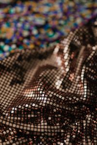 Kaboompics - Bronze Sequin Mesh Beneath Blurred Rainbow Fabric, Vertical Textile Background
