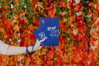 Kaboompics - Grafconf Design Conference Book and Event Badge Held over Colorful Autumn Leaves