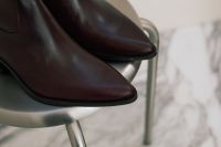 Kaboompics - Pointed Burgundy Leather Boots on a Metal Stool With Copy Space