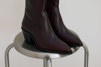 Kaboompics - Burgundy Leather Boots on a Chrome Stool for Minimalist Fashion Editorial