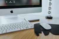 Kaboompics - Apple iMac Desktop with White Keyboard and Mouse on Black Elephant-Shaped Pad