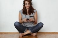Kaboompics - Beautiful young woman in headphones listening to music